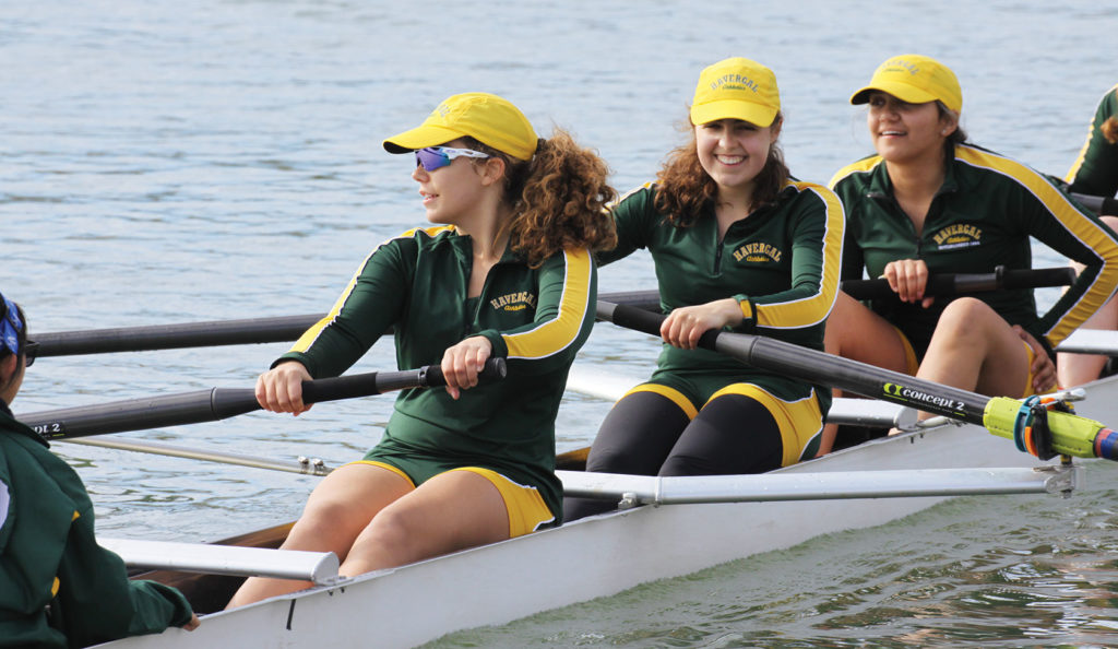 Three rowers in a boat wearing Havergal green and gold.