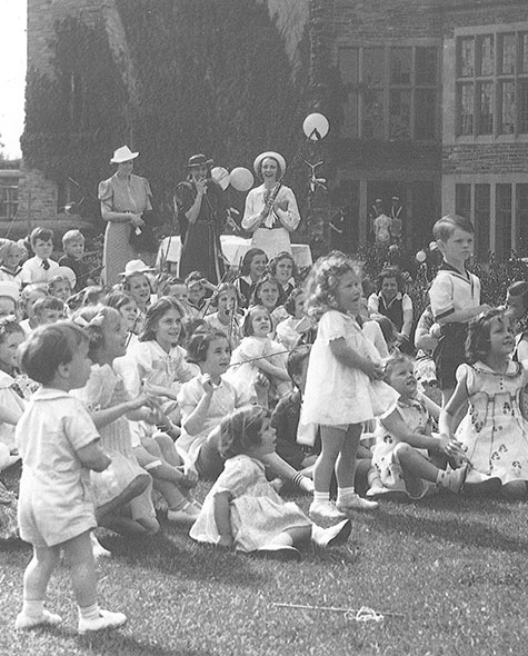 A group of toddlers sit outside in the South Quad