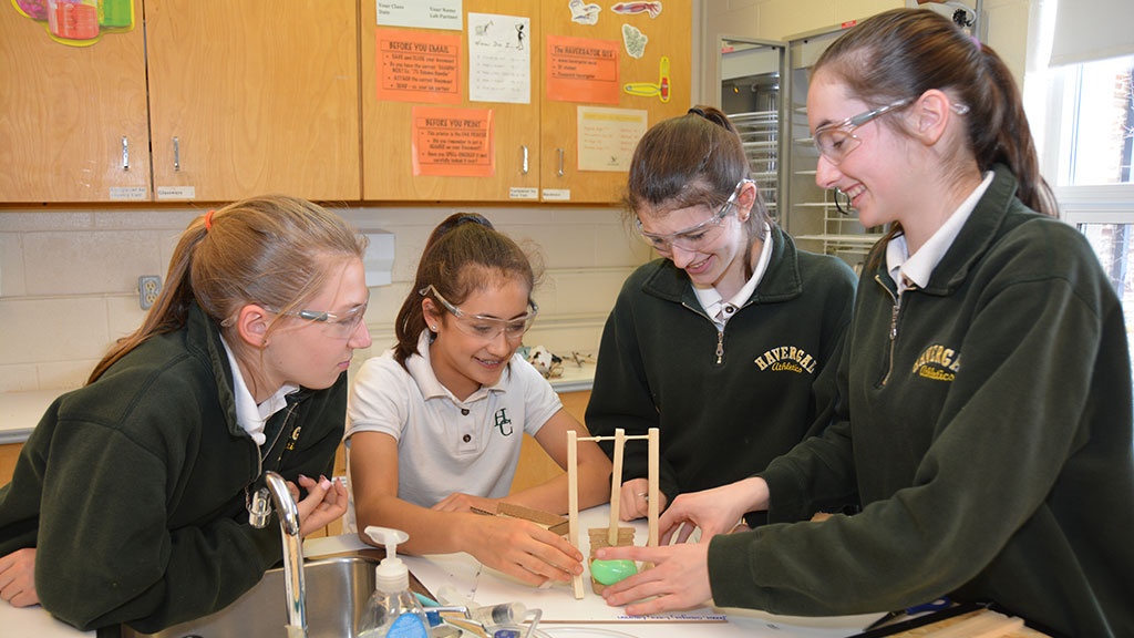 A group of four students work on a science experiment.