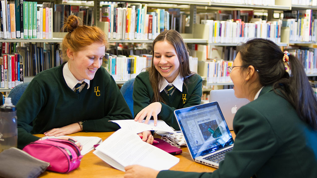 Three students study together in the library.