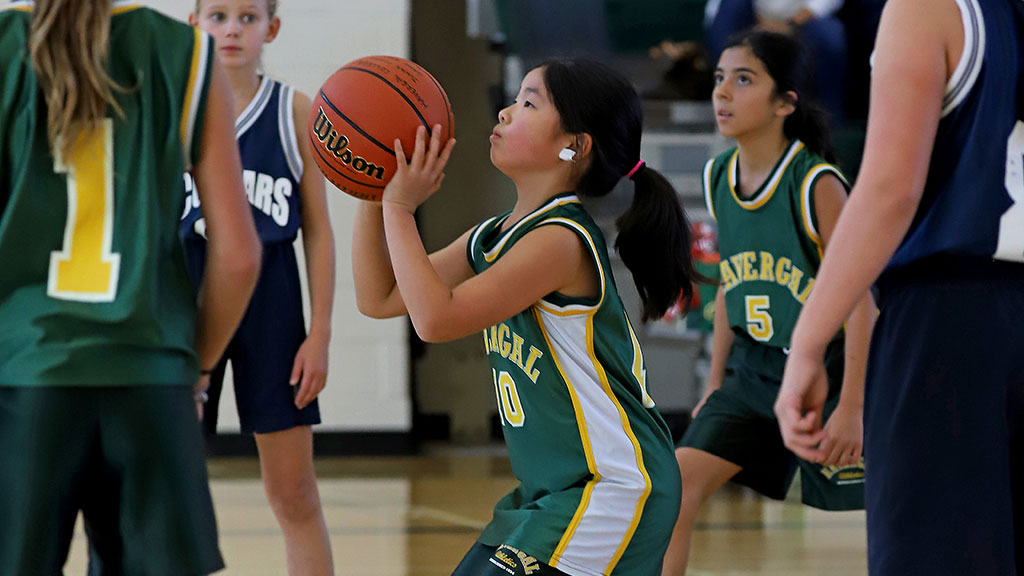 A student on the basketball team gets ready to shoot the ball during a game