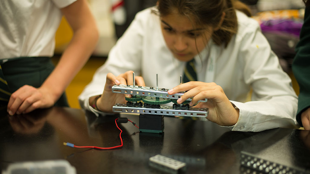 A student concentrating on building a robot.