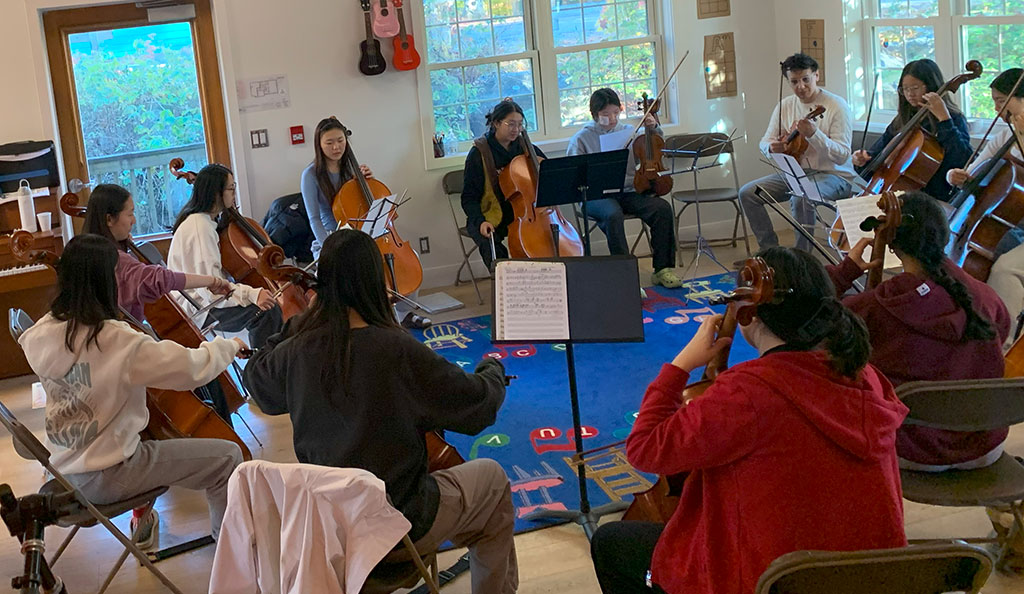 Students play violin together at a Music Retreat.