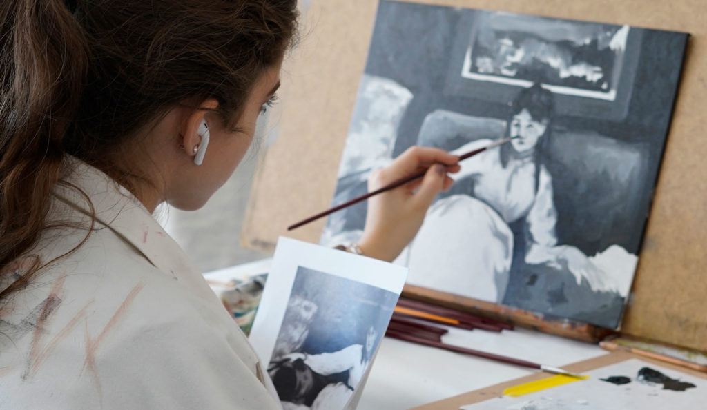 Close-up of a student painting at an easel.