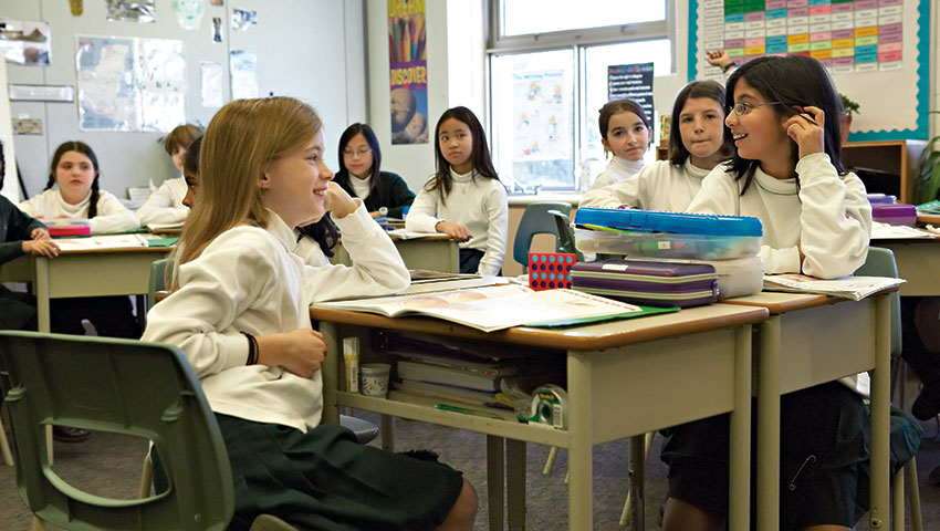 Junior School students sit at their desks in a classroom.