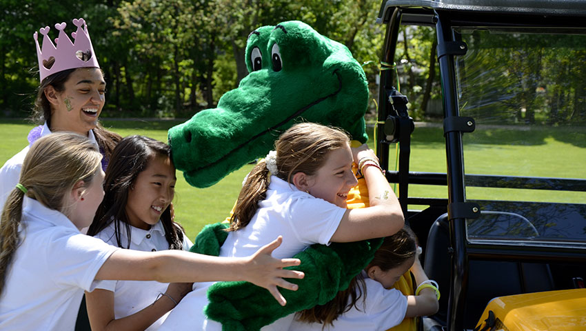 Students hug the Havergator mascot in celebration of its 20th birthday.