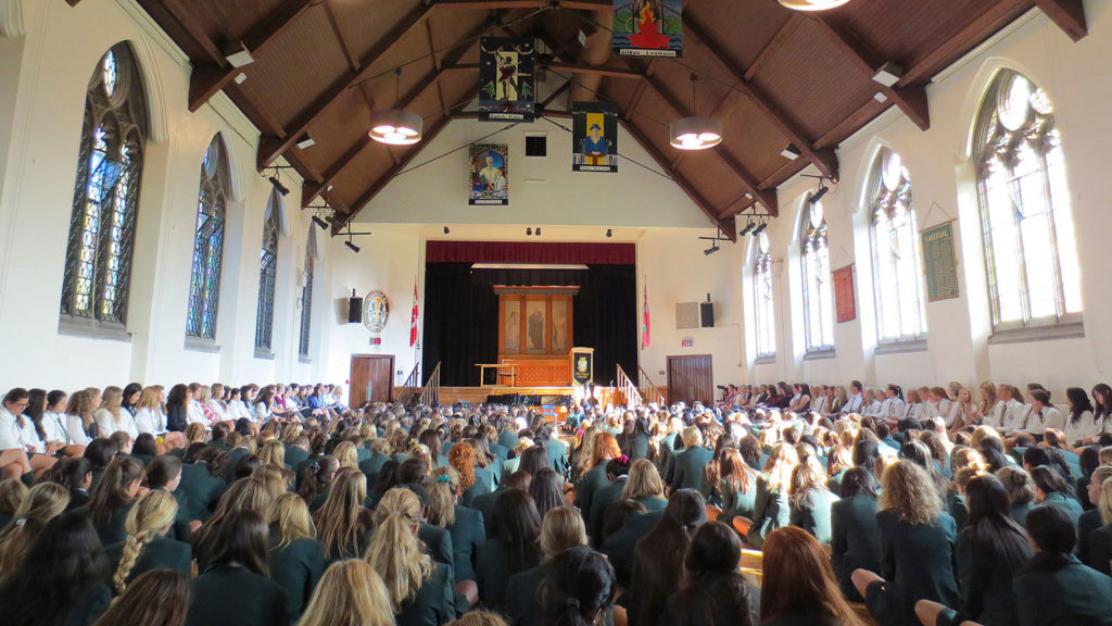 Students sit on the floor in the Brenda Robson Hall for Prayers.