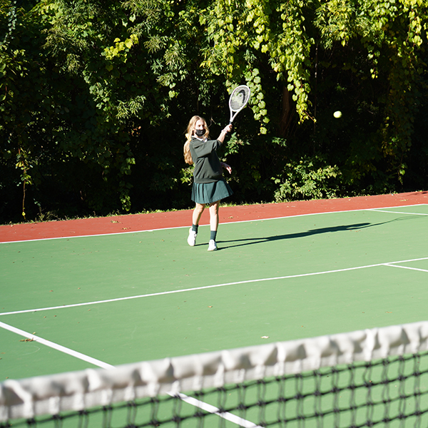 Student playing tennis