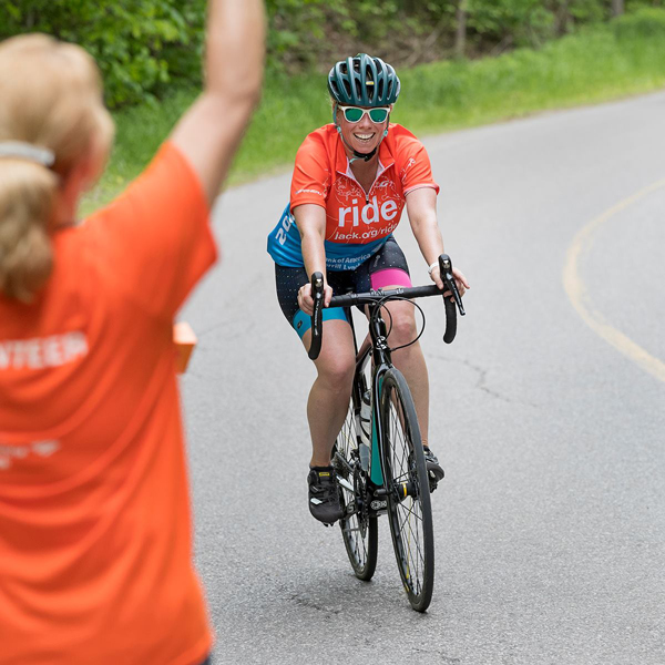 Kari Macer riding on a bike in a race