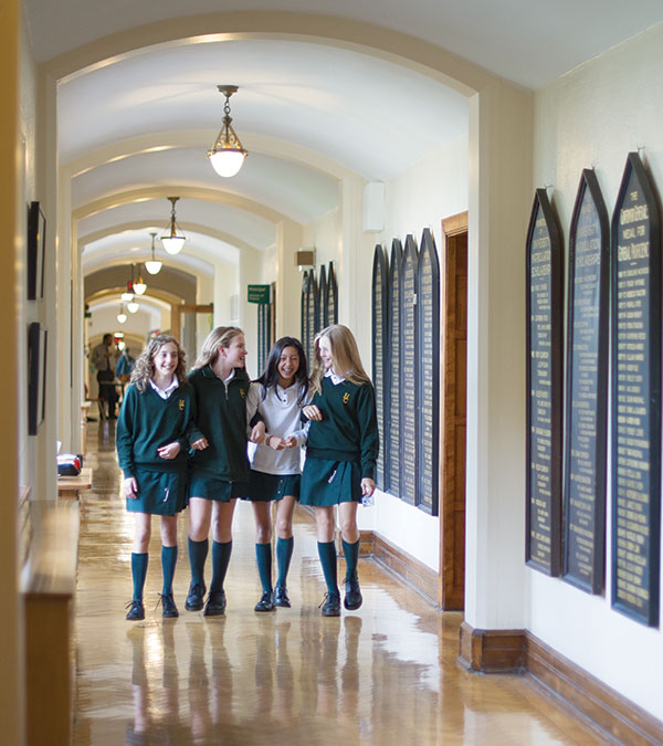 Four students walking down a hallway.