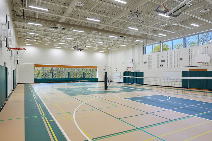 The Junior School Gym with a volleyball net set up in the middle of the room.