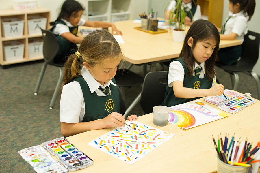 Two Junior School students work on art in a classroom.