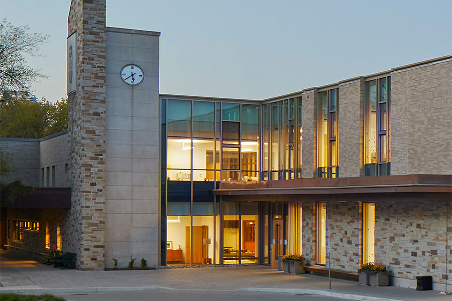 Exterior view of the main entrance doors at the Junior School at dusk. 