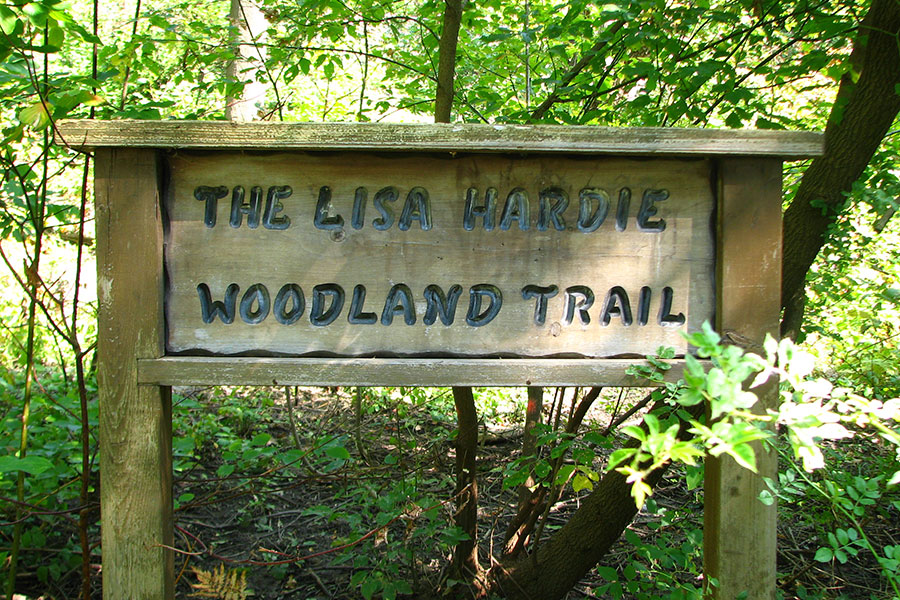 A wooden sign indicating the entrance to the Lisa Hardie Woodland Trail.