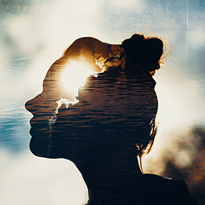Silhouette of a woman's face with a sunset in the head.