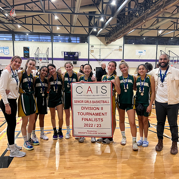 Havergal's Basketball Team holds up the CAIS championship banner.