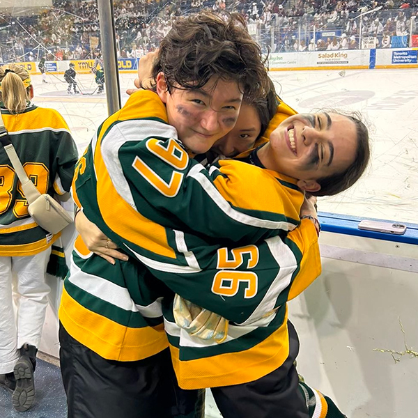 Photo of Piper and Beats hugging in their Hockey uniforms.