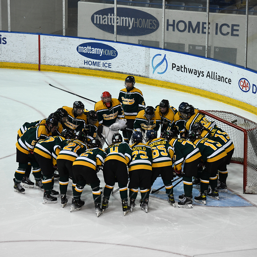 Havergal's U20 D1 Hockey Team huddled in a circle on the ice.