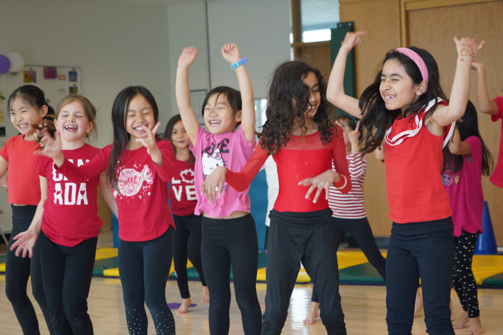 Junior School students dancing wearing red t-shirts and black pants.