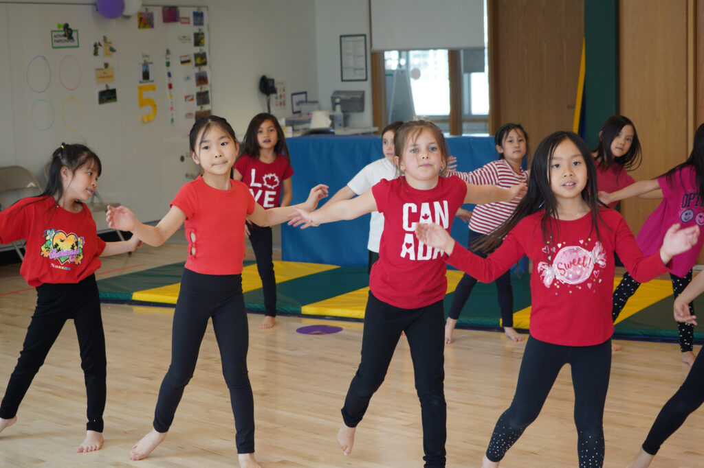 Junior School students dancing wearing red t-shirts and black pants.