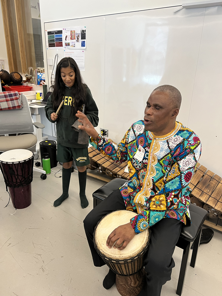 Dr. Kofi Gbolonyo on the drums, teaching students.