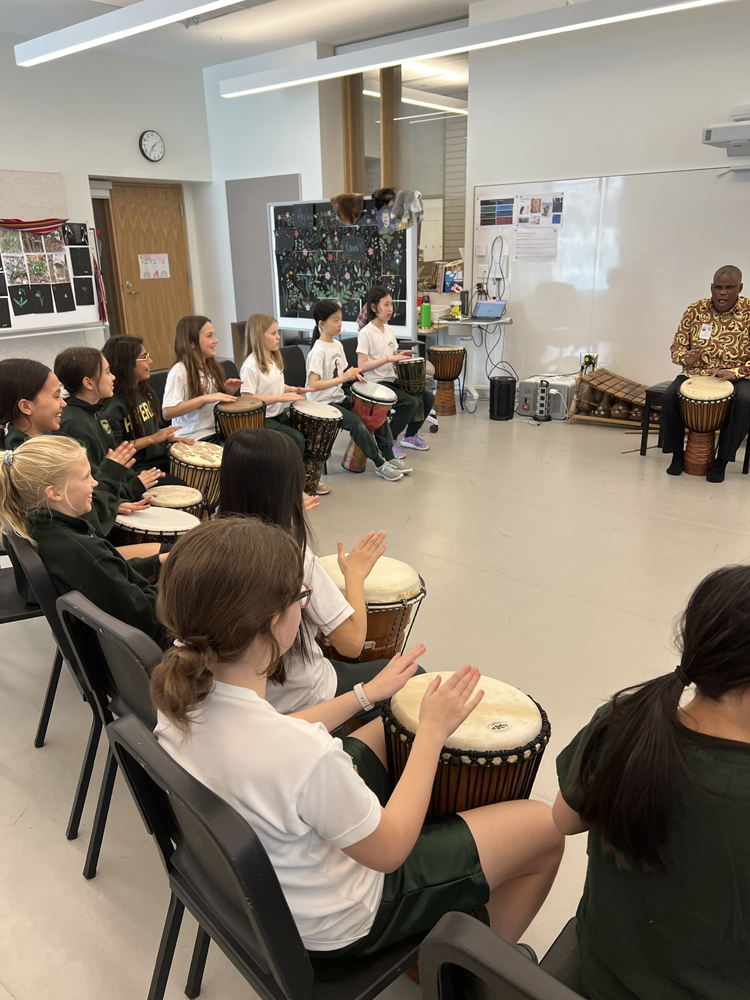 Dr. Kofi Gbolonyo teaching students to play the hand drums.