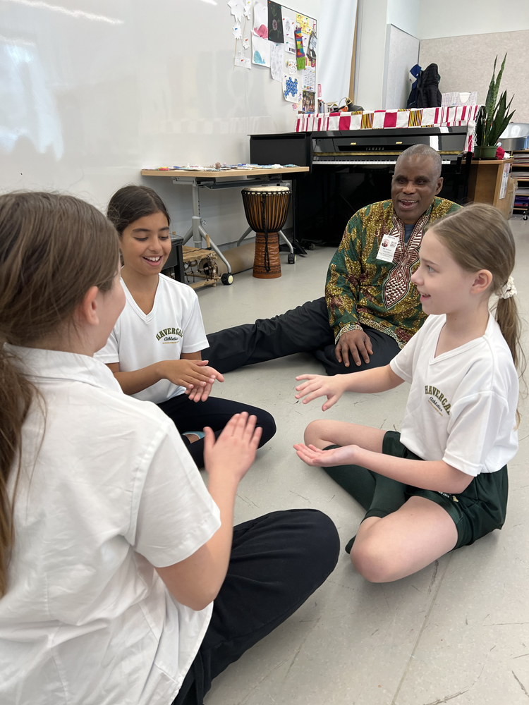 Dr. Kofi Gbolonyo with students teaching clapping games.