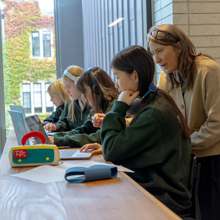 A teacher helping students with their Digital Wisdom assignments on their digital identities.