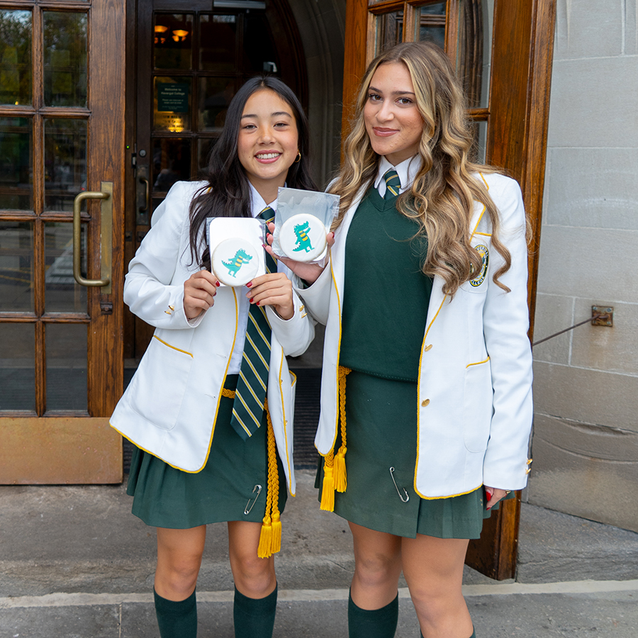Havergal Admission Prefects standing at the front of the Upper School holding Gator cookies on Open House.