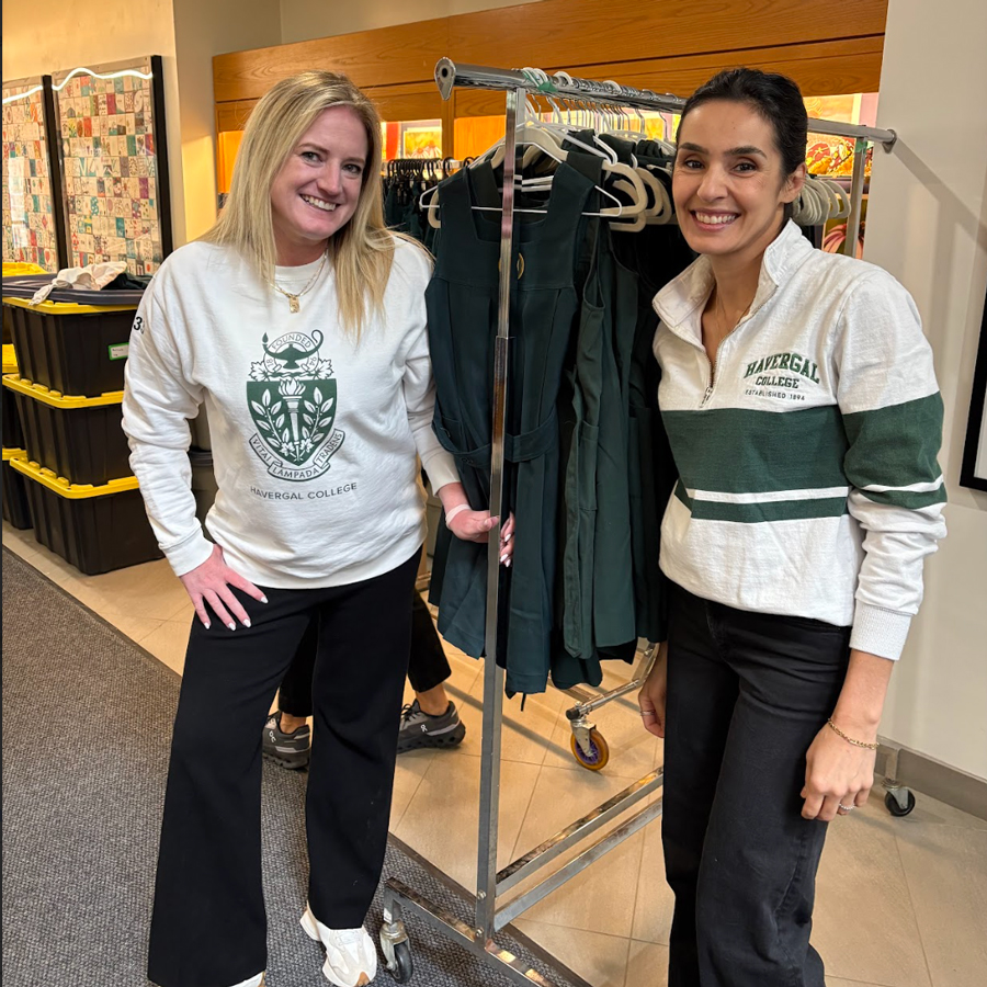 HCPA Parent Volunteers next to a clothing rack at a uniform sale.